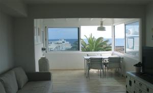 een woonkamer met een tafel en stoelen en een groot raam bij Mar de Sal in Teguise