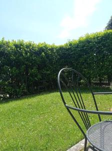 a metal chair sitting in the grass in a yard at B&B Casa Giardino Ferrazzano in Ferrazzano