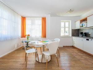 eine Küche und ein Esszimmer mit einem Tisch und Stühlen in der Unterkunft Apartment Stolzenfels-2 by Interhome in Ostseebad Sellin