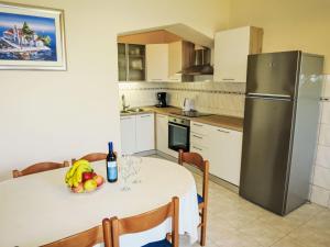 eine Küche mit einem weißen Tisch und einem Kühlschrank in der Unterkunft Holiday Home Marijana - ZAD500 by Interhome in Sukošan