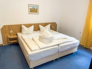a bedroom with a bed with white sheets and pillows at Apartment Villa Imperator by Interhome in Ostseebad Sellin