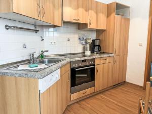 a kitchen with wooden cabinets and a sink at Apartment Villa Imperator by Interhome in Ostseebad Sellin