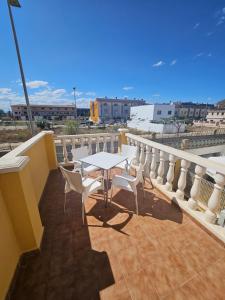 een patio met een tafel en stoelen op een balkon bij Chalet adosado in Cullera