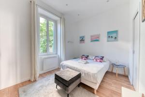 ヴィルールバンヌにあるGuestReady - Grey velvet in Villeurbanneの白いベッドルーム(ベッド1台、窓付)