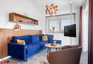 un soggiorno con divano blu e tavolo di Fewo Regenpfeifer Haus Langeoog a Hooksiel