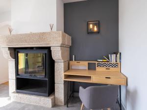 een woonkamer met een open haard en een bureau met een televisie bij Holiday Home La Vigie - LPU104 by Interhome in Clohars-Carnoët