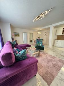 ビハチにあるFamily estate Hadžalova avlijaの紫色のソファとテーブル付きのリビングルーム