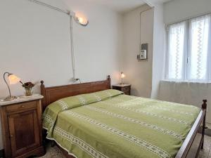 Un dormitorio con una cama con un edredón verde. en Apartment Casa Petrella - DOL137 by Interhome, en Dolcedo