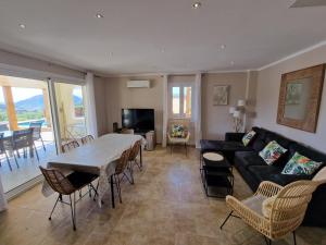 uma sala de estar com um sofá e uma mesa em Appartement Piovanacce - T3 avec pisicne privée 10min de Saint-Florent em Barbaggio