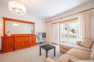 シャルネカにあるGuestReady - Caparica Beach Lover's Dreamのソファとテレビのあるリビングルーム