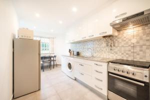a kitchen with a refrigerator and a stove top oven at GuestReady - Spacious Apt near Cascais City Centre in Cascais