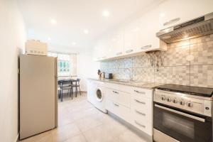 a kitchen with a refrigerator and a stove top oven at GuestReady - Spacious Apt near Cascais City Centre in Alvide