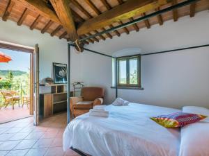 a bedroom with a bed and a chair and a patio at Apartment Casa Renai a San Gimignano-5 by Interhome in San Gimignano