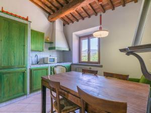 a kitchen with a wooden table and some chairs at Apartment Casa Renai a San Gimignano-5 by Interhome in San Gimignano