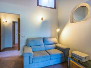 a living room with a blue couch and a mirror at Apartment Casa Renai a San Gimignano-5 by Interhome in San Gimignano