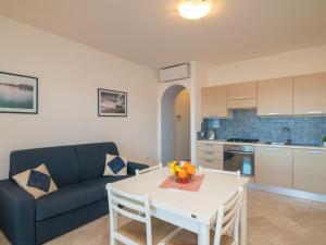 Apartment Il Fjordo bilo - PPZ160 by Interhome في بورتو بوزو: غرفة معيشة بها أريكة وطاولة عليها فاكهة