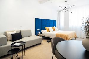 1 dormitorio con cama, sofá y mesa en Blanq Marina Suites en Valencia