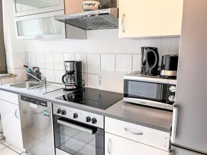 y cocina con fogones y microondas. en Apartment Ferienapartments Adenau-1 by Interhome, en Adenau