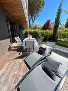 a patio with a table and chairs on a deck at Cortemaggiore 4B Luxury-Flexrent Abissinia in Riccione