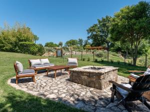a patio with couches and a stone fire pit at Holiday Home Montecavallo by Interhome in Poggio Murella