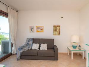 sala de estar con sofá y mesa en Apartment I Mirti di Porto Pozzo - PPZ123 by Interhome, en Porto Pozzo