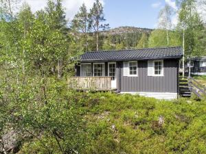 Øyuvstad的住宿－Chalet Thorabu - SOW117 by Interhome，树林中的山丘上的小房子