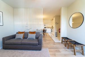a living room with a couch and a mirror at On The Square Flat - City Center by House and People in Braga