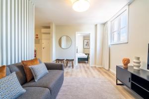 a living room with a couch and a mirror at On The Square Flat - City Center by House and People in Braga