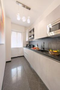 eine Küche mit weißen Schränken und einer Arbeitsplatte in der Unterkunft Ca' Disa - Loft moderno centro città in Rapallo