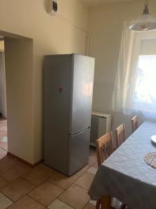 kuchnia ze stołem i srebrną lodówką w obiekcie Dyta2 apartman w Hajduszoboszlo