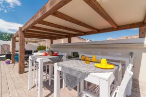 a patio with white tables and white chairs on a deck at Marina Di Castello in Cagliari