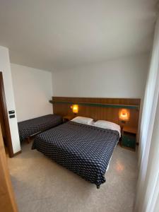 1 dormitorio con 2 camas y 2 luces en la pared en Hotel Ca' Di Valle, en Cavallino-Treporti