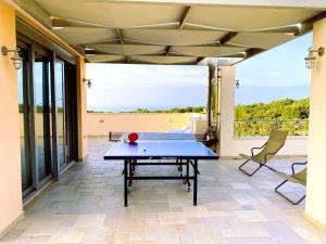 un tavolo da ping pong su un patio di Deluxe Villa Ianthos - Outdoor Hot Tub & Kids Pool a Gállos