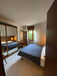 Habitación de hotel con 2 camas y espejo en Hotel Ca' Di Valle, en Cavallino-Treporti