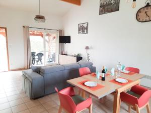 een woonkamer met een tafel en een bank bij Les Hauts de Sarlat G4 - Clim Piscine Parking WiFi in Sarlat-la-Canéda