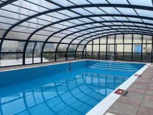 a large swimming pool with a glass roof at Sunrise in Brixham