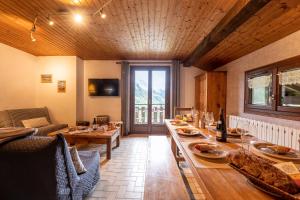 una sala de estar con una mesa larga y un sofá en Chalet Le Grand Nant, en La Giettaz