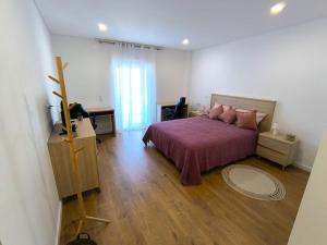 a bedroom with a bed with a purple bedspread at Full Nathur I Central Ericeira in Ericeira