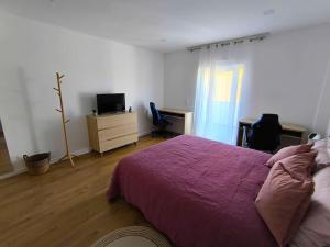 a bedroom with a bed and a desk and a television at Full Nathur I Central Ericeira in Ericeira