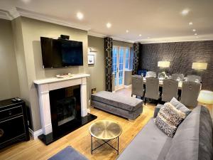 a living room with a couch and a fireplace at Honey Hill Cottage - 4 Bedroom Detached House in Cambridge