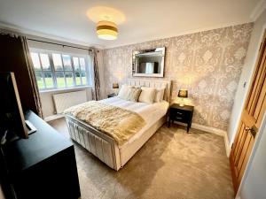 - une chambre avec un grand lit et une fenêtre dans l'établissement Honey Hill Cottage - 4 Bedroom Detached House, à Cambridge