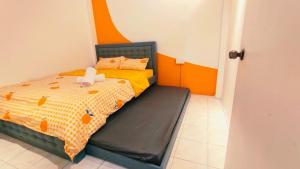 a bedroom with a bed with an orange and yellow comforter at Kulai Tmn Putri Tmn Gunung Pulai Tmn Baiduri Tmn Kota Kulai Tmn Lagenda Kulai 3-5BR near Airport JPO IOI in Kulai