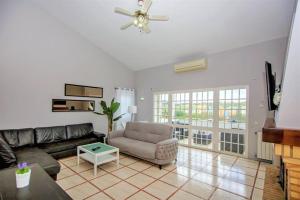 sala de estar con sofá y ventilador de techo en Vila Ventura Marina, en Albufeira