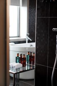 卑爾根的住宿－卑爾根機場凱瑞酒店，浴室设有水槽和装有瓶子的台面