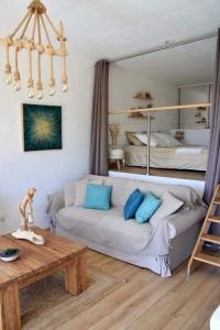 sala de estar con sofá y cama en Villa les Alizés en Rayol-Canadel-sur-Mer