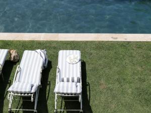 dos sillas sentadas en el césped junto a una piscina en Constantia Klein en Ciudad del Cabo