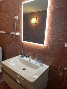 La salle de bains est pourvue d'un lavabo blanc et d'un miroir. dans l'établissement House Riva, à Pirovac