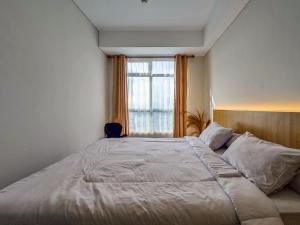 a bedroom with a large bed and a window at Borneo Bay City Apartment, 1BR in Klandasan Kecil +18 photos