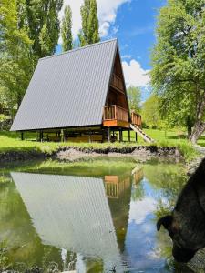 a barn with a reflection in a pond at Phaliani's Heaven in Mestia