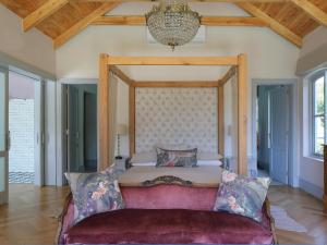 1 dormitorio con cama grande y sofá rojo en Constantia Klein en Ciudad del Cabo